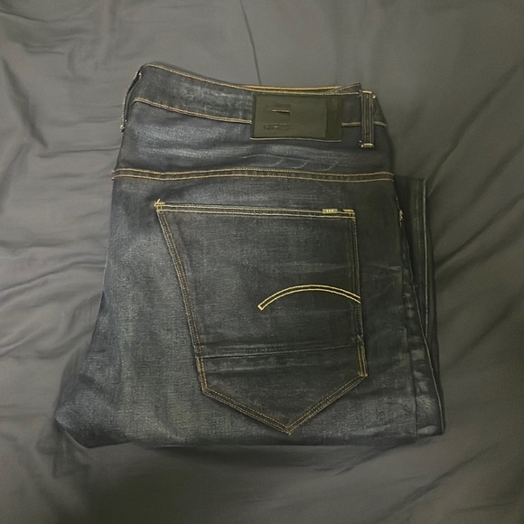 Worn GStar jeans. Deep blue jeans. Slim straight fit. Ridged fit.